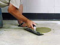 Repairing the cored holes in the concrete slab floor with fresh concrete and cleaning up the Galloway home.