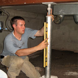 A contractor in Mansfield installing a crawl space jack post.
