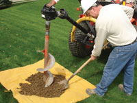 Auguring a hole in the earth for a foundation wall repair system in Galloway