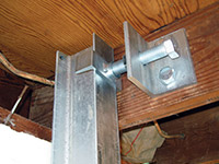 Securing the i-beam system to the top of the floor joist in a foundation wall repair in Galloway.