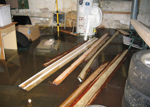 A severely flooding basement in Galloway, with lumber and personal items floating in a foot of water
