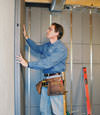 Insulated basement wall panels being placed against a concrete foundation wall in Marysville